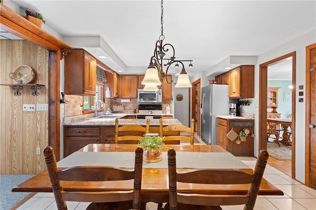 133 Parklands Dr, Greece, NY 14616 - kitchen featuring stainless steel appliances, light countertops, backsplash, brown cabinets, and light tile patterned flooring