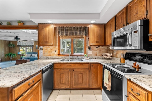 133 Parklands Dr, Greece, NY 14616 - kitchen with appliances with stainless steel finishes, brown cabinets, light tile patterned floors, light stone countertops, and recessed lighting