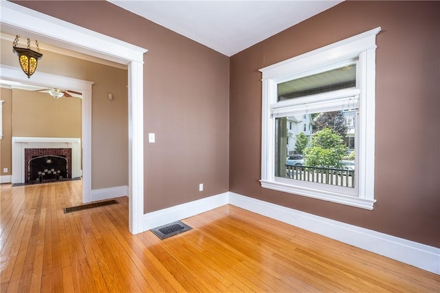 34 Shepard St, Rochester, NY 14620 - spare room featuring light wood-style flooring, a ceiling fan, and a fireplace with flush hearth