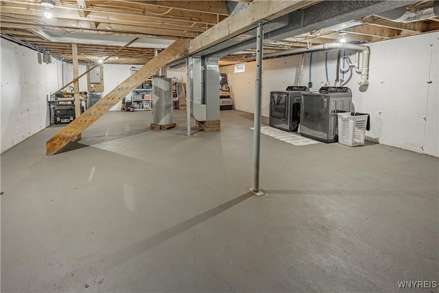 1558 Youngstown Wilson Rd, Porter, NY 14174 - unfinished basement featuring washing machine and dryer, stairs, gas water heater, and electric panel