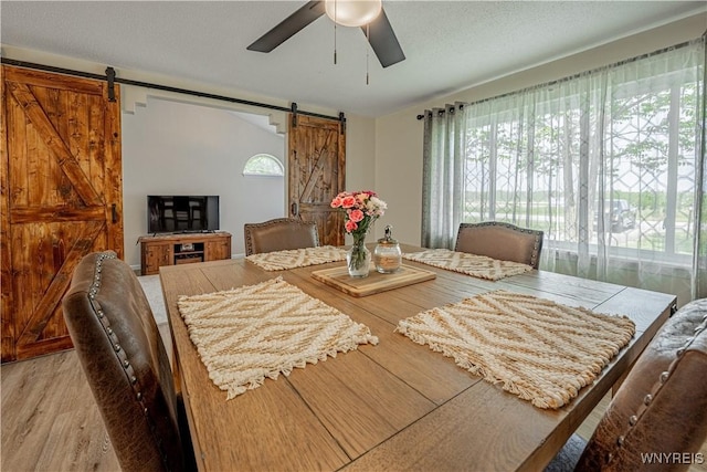 1558 Youngstown Wilson Rd, Porter, NY 14174 - dining room featuring a barn door, ceiling fan, healthy amount of natural light, and light wood-style floors
