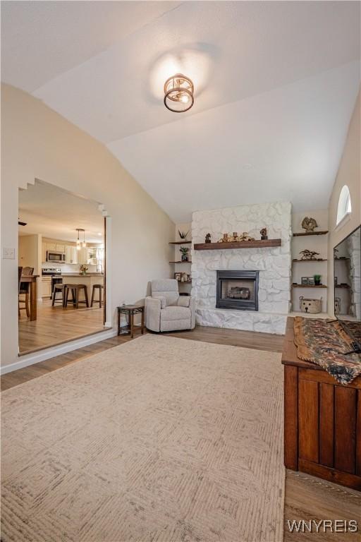 1558 Youngstown Wilson Rd, Porter, NY 14174 - living room featuring lofted ceiling, wood finished floors, and a fireplace