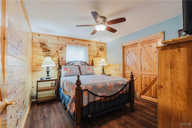 6938 Klock Rd, Lyme, NY 13693 - bedroom with wood walls, dark wood finished floors, and a ceiling fan