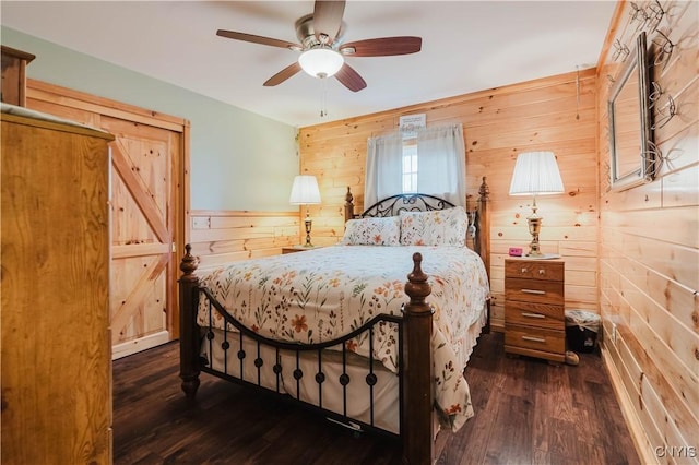6938 Klock Rd, Lyme, NY 13693 - bedroom with wood walls, dark wood finished floors, ceiling fan, and a wainscoted wall