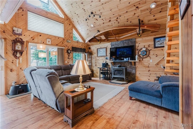 6938 Klock Rd, Lyme, NY 13693 - living room with wood walls, a wood stove, high vaulted ceiling, wood finished floors, and a skylight
