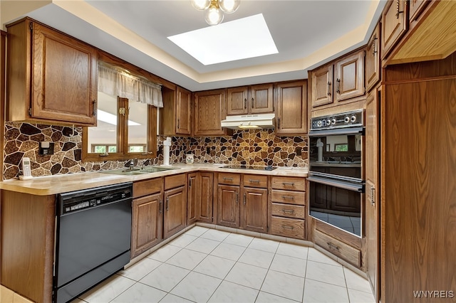 6182 Townline Rd, Wheatfield, NY 14094 - kitchen with black appliances, a skylight, brown cabinets, and under cabinet range hood