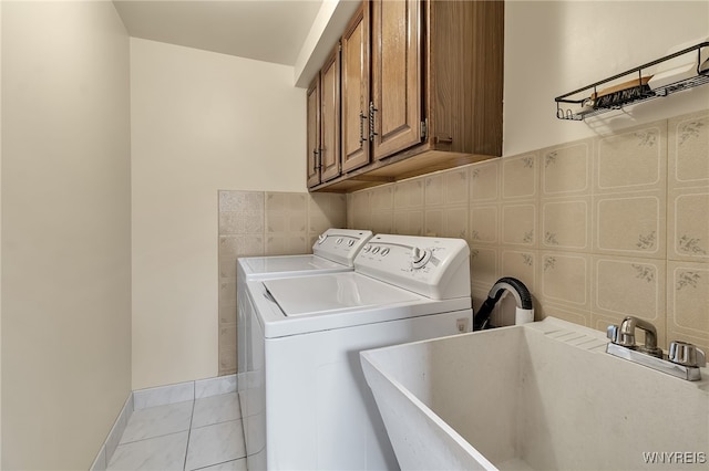 6182 Townline Rd, Wheatfield, NY 14094 - laundry area featuring cabinet space, washing machine and dryer, and light tile patterned floors
