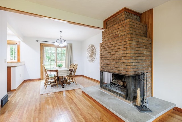 16 Clearview Dr, Henrietta, NY 14534 - dining room featuring wood finished floors, a chandelier, and a brick fireplace