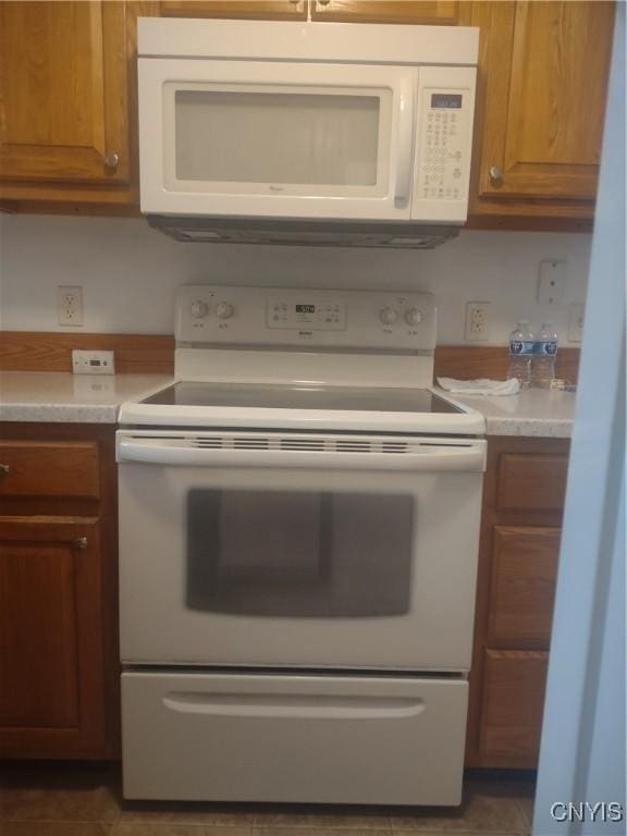 407 Fultz Dr, Oneida-Inside, NY 13421 - kitchen featuring white appliances, brown cabinetry, and light countertops