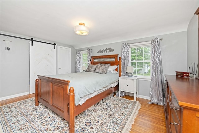 30 Northfield Rd, Irondequoit, NY 14617 - bedroom with light wood-style flooring and a barn door