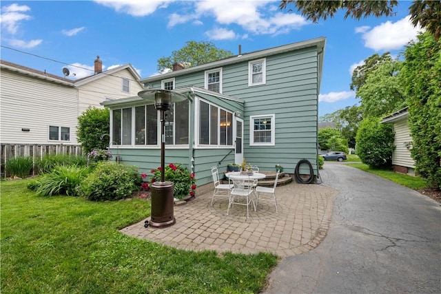 30 Northfield Rd, Irondequoit, NY 14617 - back of house featuring a patio, a sunroom, and a chimney