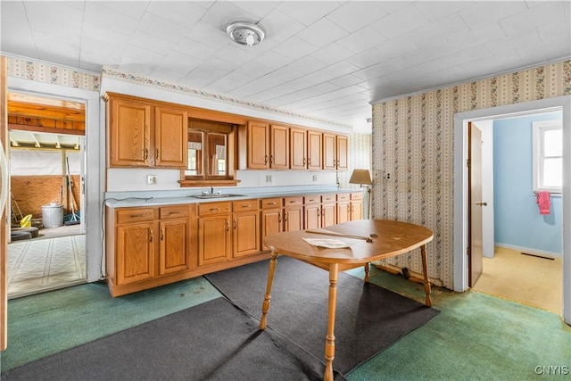 7418 Main St, Newport, NY 13416 - kitchen featuring light countertops, wallpapered walls, carpet flooring, and brown cabinets