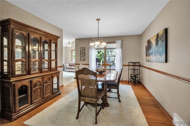 139 Autumn Creek Ct, Amherst, NY 14051 - dining area with a chandelier, light wood finished floors, and a textured ceiling