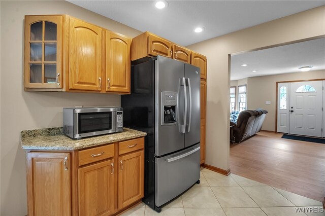 139 Autumn Creek Ct, Amherst, NY 14051 - kitchen featuring stainless steel appliances, glass insert cabinets, light stone counters, light tile patterned floors, and recessed lighting