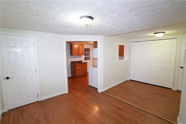 556 Middle Rd, Henrietta, NY 14467 - unfurnished bedroom featuring wood finished floors, a textured ceiling, and a closet