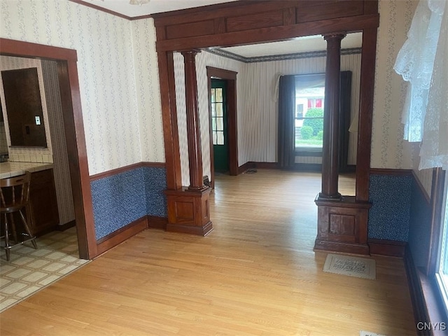 205 Morton St, Syracuse, NY 13204 - hallway featuring ornate columns, wallpapered walls, and light wood-style floors