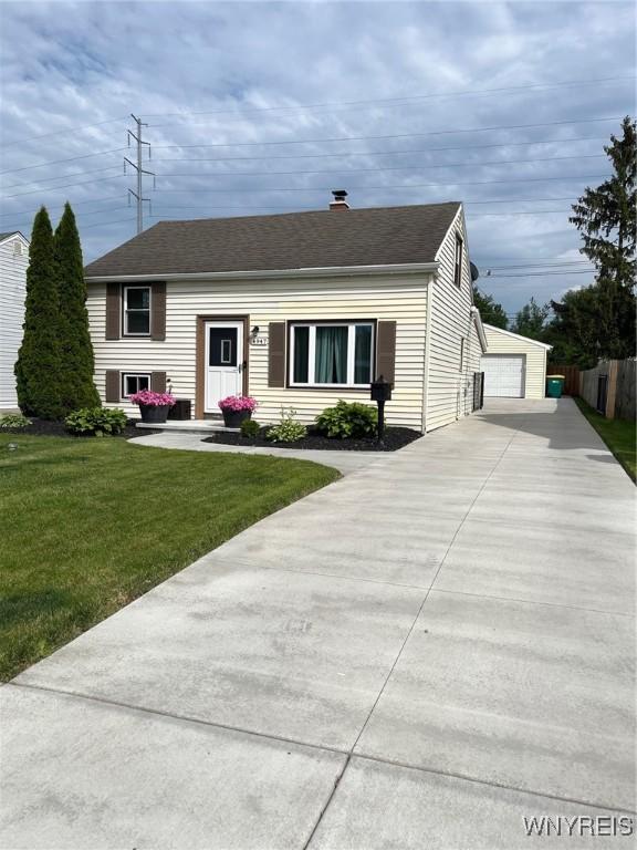 4947 Morgan Pkwy, Hamburg, NY 14075 - view of front of house featuring a front yard, a garage, a chimney, and roof with shingles