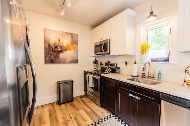94 Birchwood Dr, Irondequoit, NY 14622 - kitchen featuring stainless steel appliances, white cabinets, light wood finished floors, backsplash, and track lighting