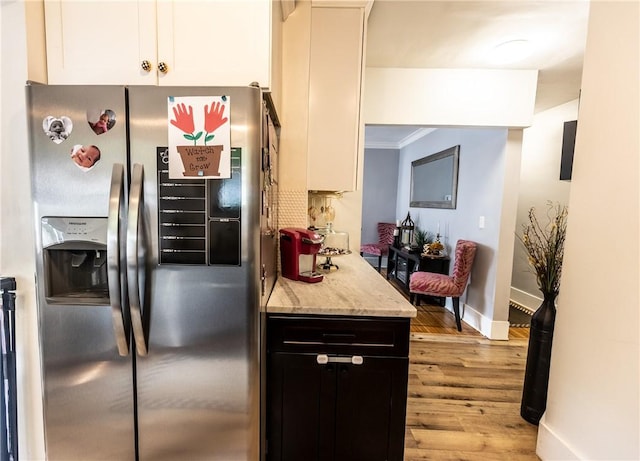 94 Birchwood Dr, Irondequoit, NY 14622 - kitchen with stainless steel refrigerator with ice dispenser, light wood-type flooring, light stone counters, white cabinets, and ornamental molding