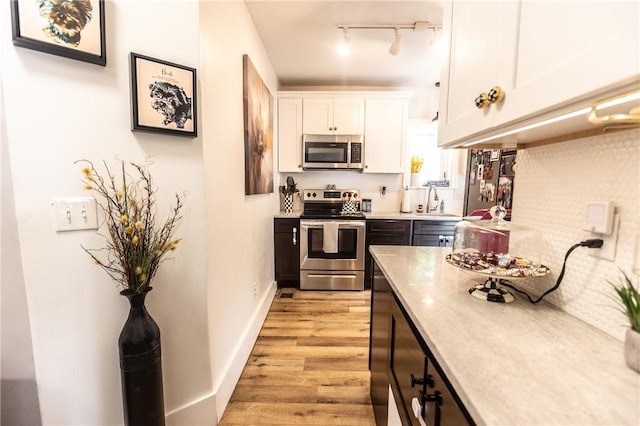 94 Birchwood Dr, Irondequoit, NY 14622 - kitchen featuring stainless steel appliances, light wood-style floors, white cabinetry, track lighting, and light countertops