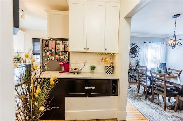 94 Birchwood Dr, Irondequoit, NY 14622 - kitchen with a chandelier, light countertops, tasteful backsplash, white cabinets, and light wood-type flooring