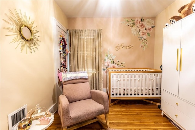 94 Birchwood Dr, Irondequoit, NY 14622 - bedroom featuring radiator, a nursery area, and wood finished floors