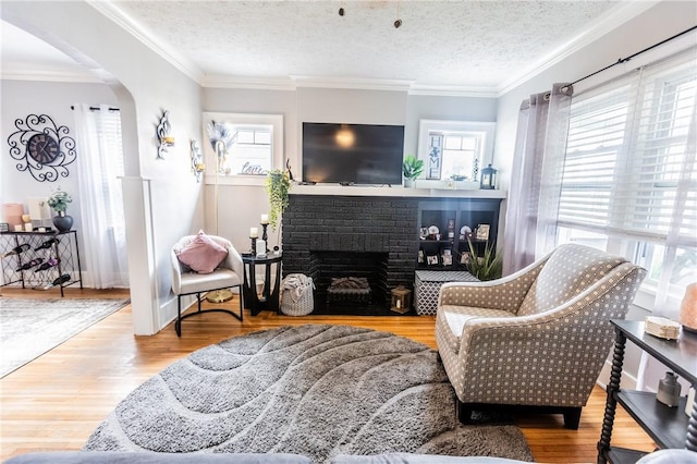 94 Birchwood Dr, Irondequoit, NY 14622 - living room with healthy amount of natural light, arched walkways, wood finished floors, a brick fireplace, and crown molding