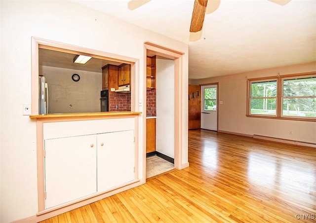 3959 Number Nine Rd, Cazenovia, NY 13035 - kitchen with light wood finished floors, stainless steel fridge, ceiling fan, white cabinets, and black oven