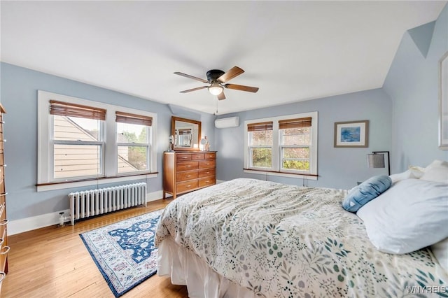 176 Mount Vernon Rd, Amherst, NY 14226 - bedroom featuring radiator, multiple windows, a wall mounted air conditioner, and light wood-style floors