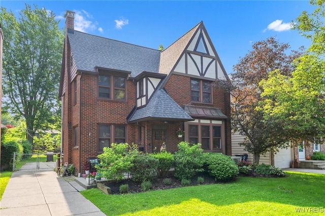176 Mount Vernon Rd, Amherst, NY 14226 - tudor-style house featuring a shingled roof, a gate, brick siding, and a chimney