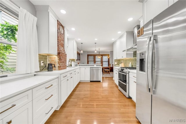176 Mount Vernon Rd, Amherst, NY 14226 - kitchen featuring appliances with stainless steel finishes, wall chimney exhaust hood, a peninsula, tasteful backsplash, and white cabinets