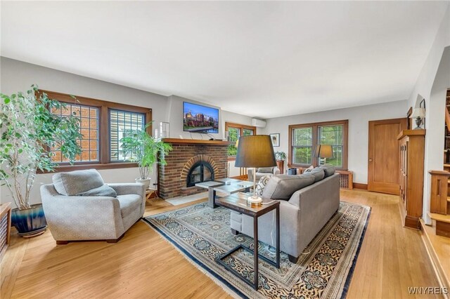 176 Mount Vernon Rd, Amherst, NY 14226 - living room with light wood-style flooring, a brick fireplace, and a wall mounted air conditioner