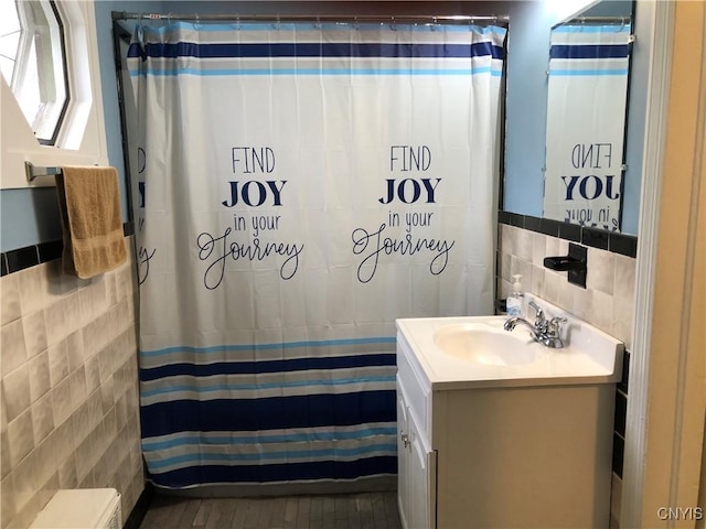 1407 N James St, Rome-Inside, NY 13440 - bathroom with tile walls, vanity, and curtained shower