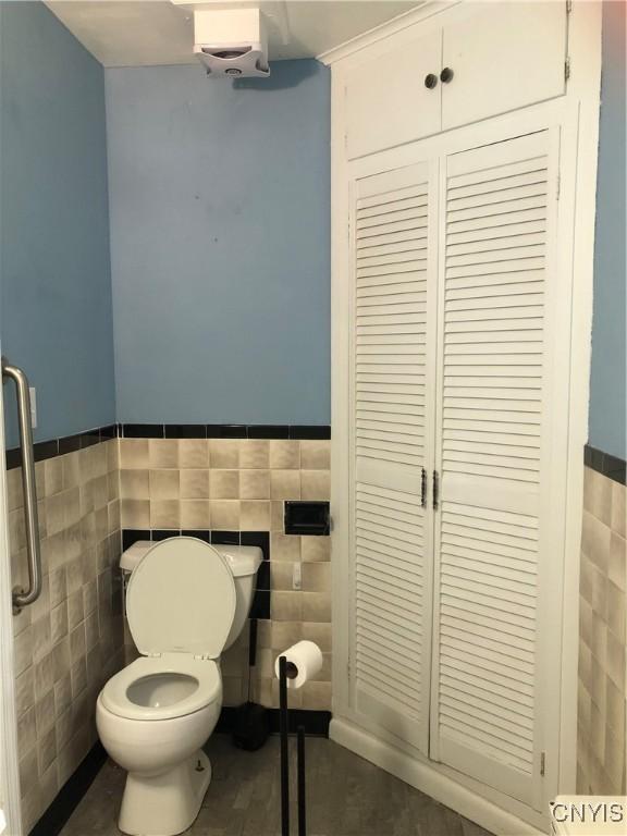 1407 N James St, Rome-Inside, NY 13440 - bathroom featuring tile walls, a closet, and a wainscoted wall