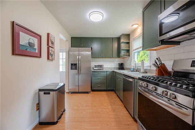 284 Woodruff Dr, Webster, NY 14580 - kitchen featuring appliances with stainless steel finishes, green cabinets, light wood-style flooring, tasteful backsplash, and open shelves