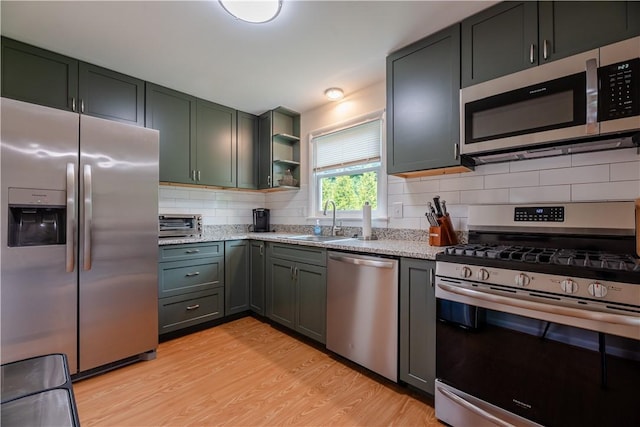 284 Woodruff Dr, Webster, NY 14580 - kitchen featuring appliances with stainless steel finishes, backsplash, light stone counters, light wood-type flooring, and open shelves
