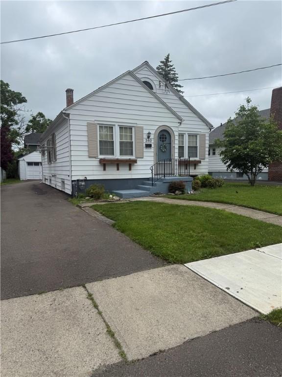 340 Webber Pl, Elmira-City, NY 14901 - view of front of home with asphalt driveway, a front lawn, a chimney, and an outdoor structure