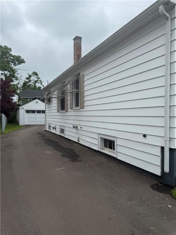340 Webber Pl, Elmira-City, NY 14901 - view of property exterior with a chimney, a garage, an outbuilding, and driveway