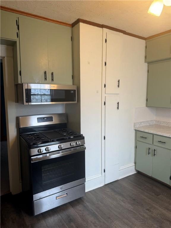 340 Webber Pl, Elmira-City, NY 14901 - kitchen with stainless steel appliances, decorative backsplash, ornamental molding, light countertops, and dark wood-style floors