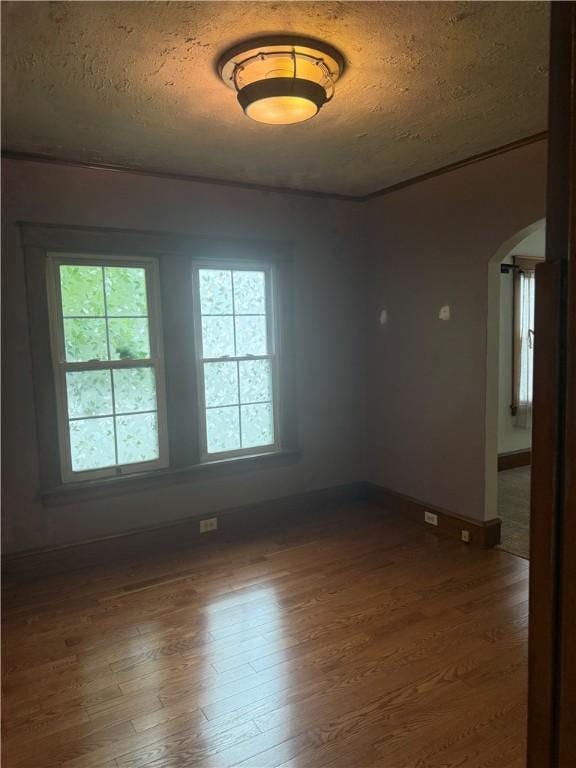 340 Webber Pl, Elmira-City, NY 14901 - unfurnished room featuring arched walkways, dark wood finished floors, plenty of natural light, and a textured ceiling