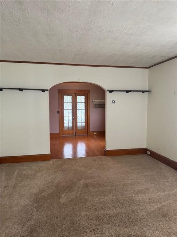 340 Webber Pl, Elmira-City, NY 14901 - empty room featuring arched walkways, carpet flooring, a textured ceiling, ornamental molding, and french doors