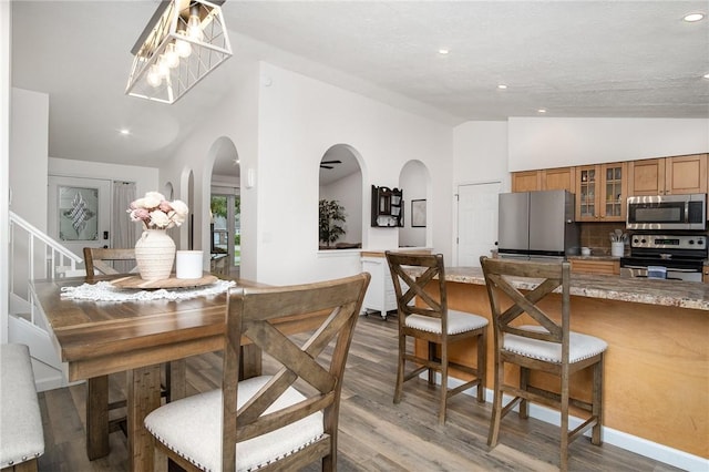 55 Creighton Ln, Greece, NY 14612 - dining space with vaulted ceiling, dark wood-style flooring, arched walkways, and recessed lighting