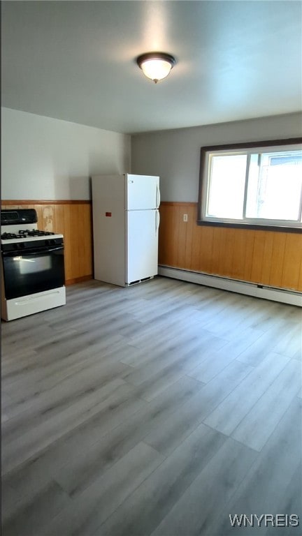 34 Reservation St, Buffalo, NY 14207 - kitchen with white appliances, a baseboard heating unit, a wainscoted wall, light wood-type flooring, and wooden walls