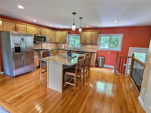 40 Ice Rose Ln, Henrietta, NY 14623 - kitchen with stainless steel appliances, a kitchen bar, light wood finished floors, backsplash, and recessed lighting