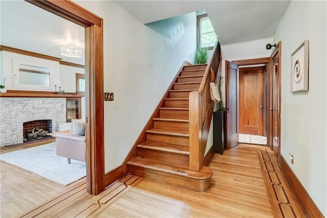 79 Rawlinson Rd, Irondequoit, NY 14617 - staircase featuring wood finished floors and a stone fireplace