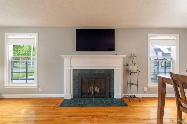 232 Kenview Blvd, Cheektowaga, NY 14215 - detailed view of wood finished floors, a tiled fireplace, and a textured ceiling