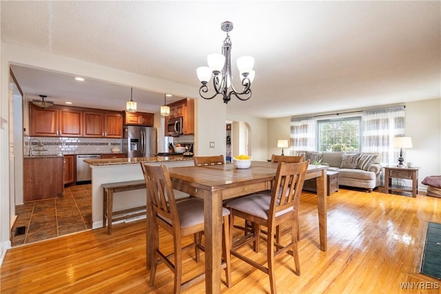 232 Kenview Blvd, Cheektowaga, NY 14215 - dining space featuring a chandelier, light wood finished floors, arched walkways, and recessed lighting