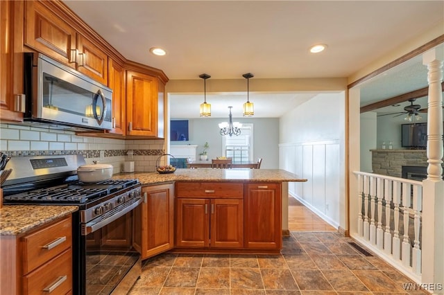 232 Kenview Blvd, Cheektowaga, NY 14215 - kitchen with appliances with stainless steel finishes, brown cabinets, a peninsula, ceiling fan, and tasteful backsplash