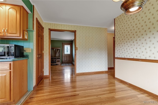 218 Hall Rd, Lancaster, NY 14059 - kitchen with black microwave, crown molding, light wood-type flooring, wallpapered walls, and dark countertops