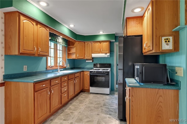 218 Hall Rd, Lancaster, NY 14059 - kitchen featuring white gas range, under cabinet range hood, dark countertops, brown cabinets, and ornamental molding